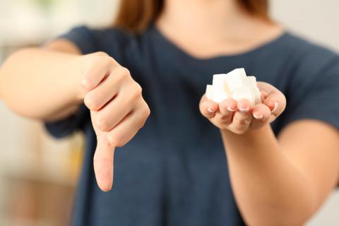 Una chica con terrones de azucar diciendo que no con el dedo